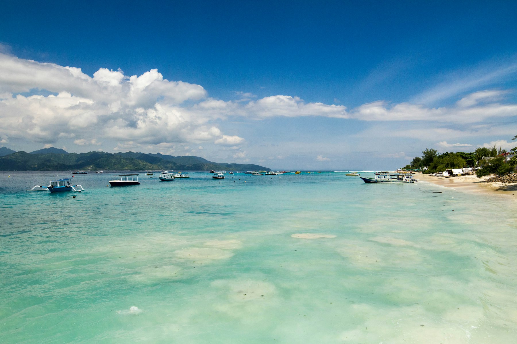 Pantai Gili Trawangan dengan perahu dan laut biru di Lombok
